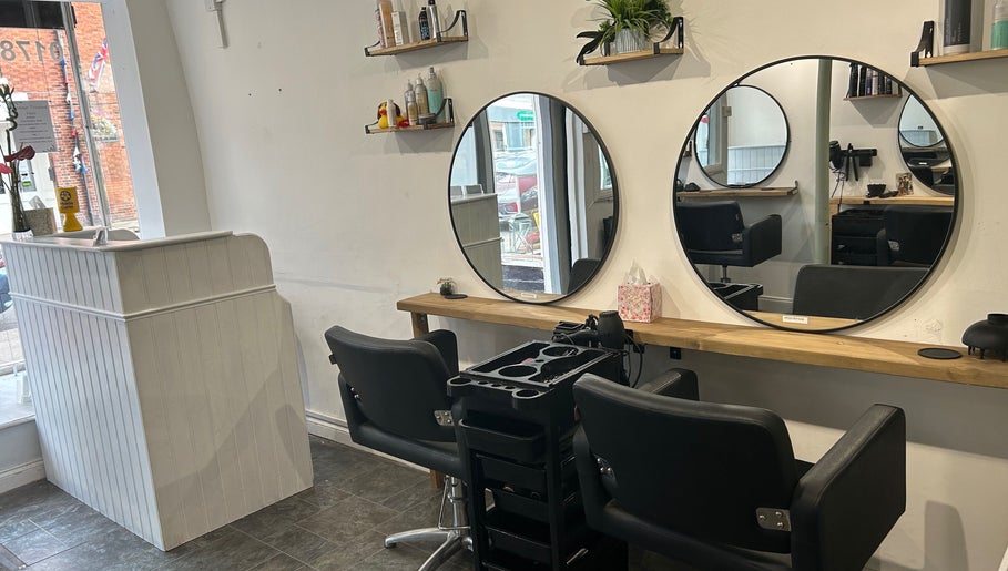 Modern salon interior at Serenity Hair & Beauty, Alcester, England, GB with sleek styling chairs and mirrors.
