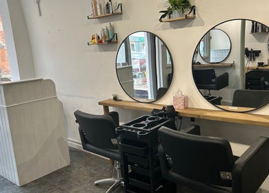 Modern salon interior at Serenity Hair & Beauty, Alcester, England, GB with sleek styling chairs and mirrors.