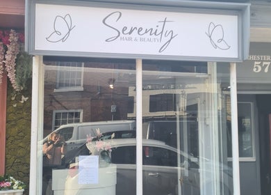 Front of Serenity Hair & Beauty, Alcester, England, GB with stylish signage and floral decor.