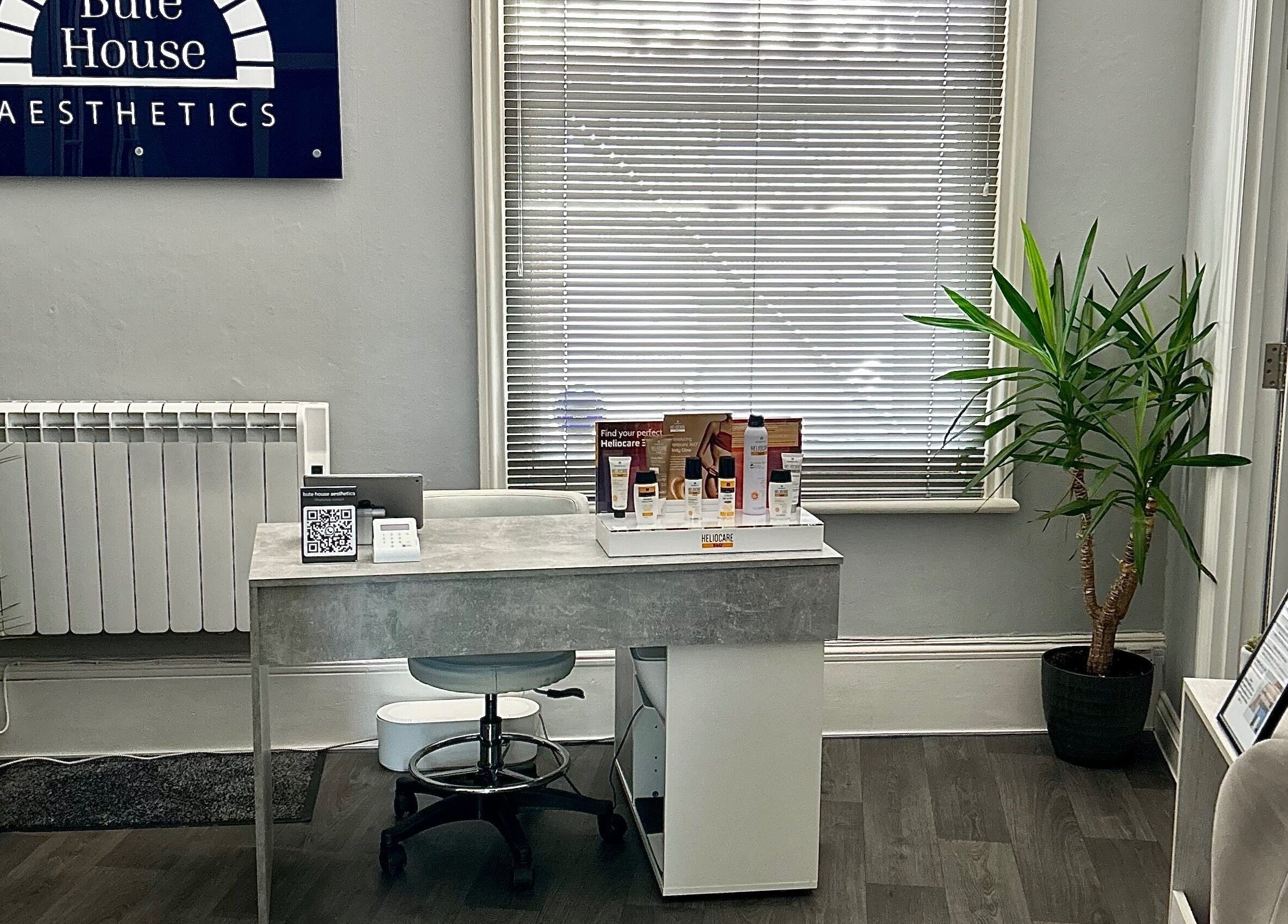 Reception area at Bute House Aesthetics, Newmarket, England, GB with modern desk, chair, and decor.