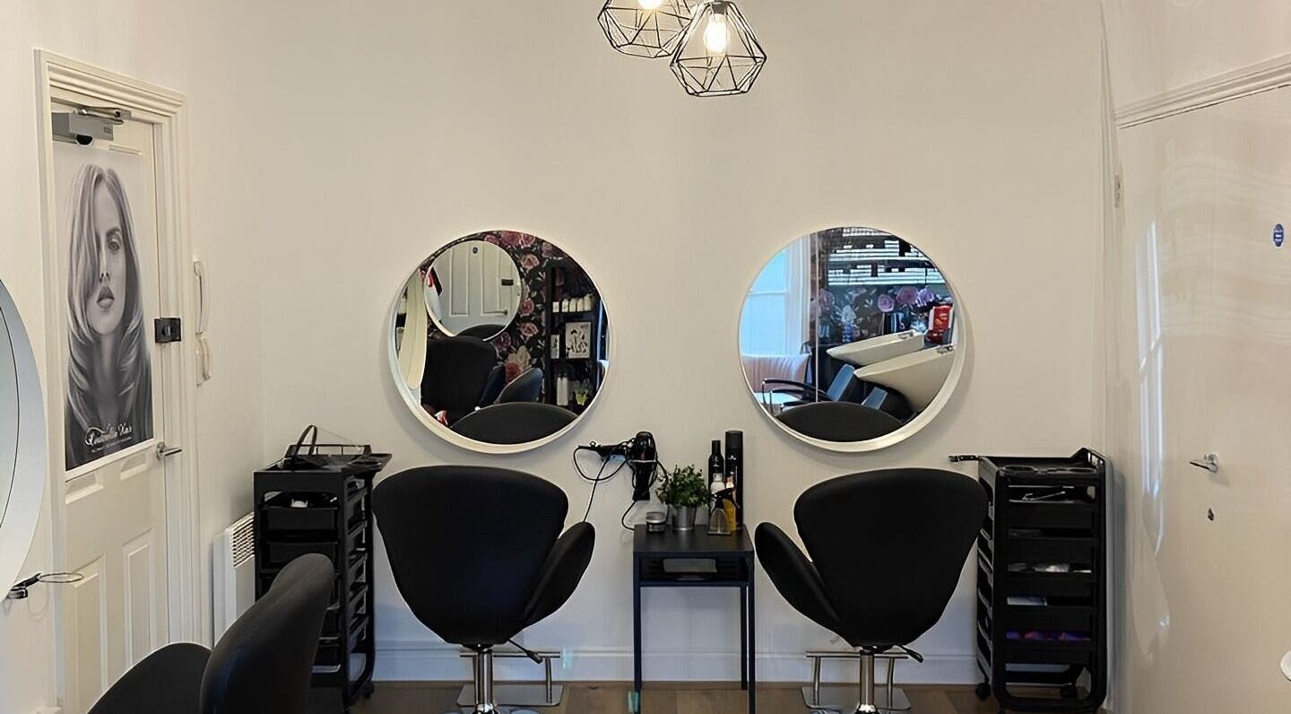 Modern hairdressing station at Adorn Hairdressing, Hoddesdon, England, GB with chic mirrors and seating.