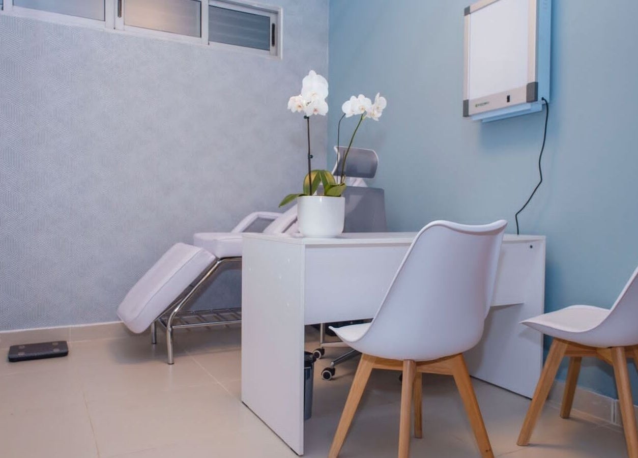 Sala de tratamiento en Fisio Balance, Santiago De Los Caballeros, Santiago, DO, con orquídea blanca en la mesa.