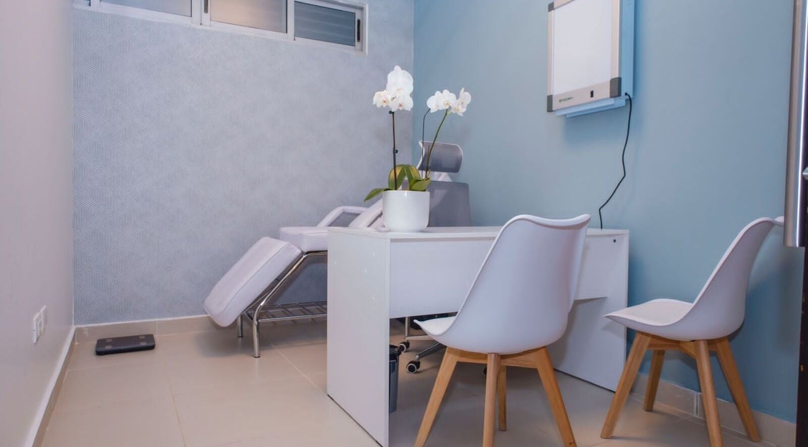 Sala de tratamiento en Fisio Balance, Santiago De Los Caballeros, Santiago, DO, con orquídea blanca en la mesa.