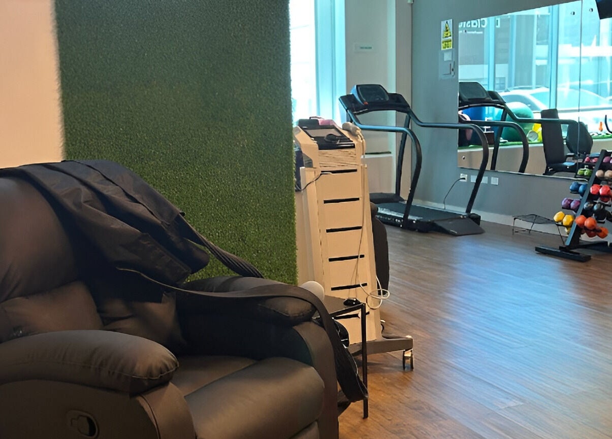 Gimnasio moderno en Fisio Balance, Santiago De Los Caballeros, equipado con sillón de masaje y pesas.