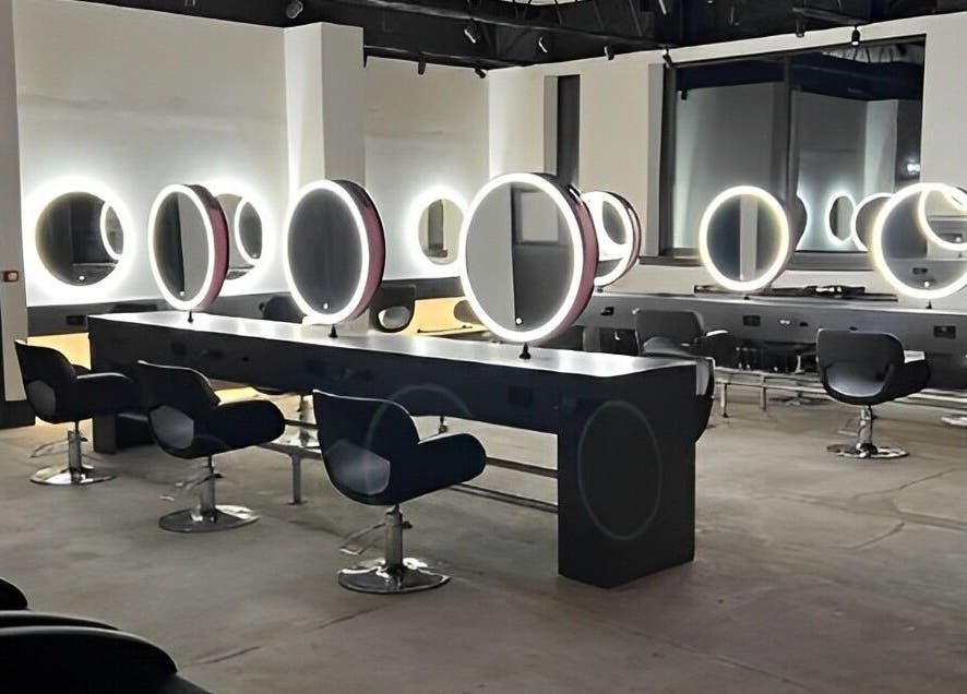 Modern salon interior at Calum Maguire Hairdressing, Ayr, Scotland, GB with sleek chairs and illuminated mirrors.