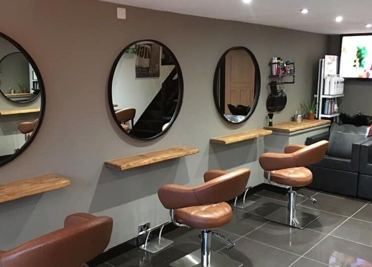 Modern salon interior at Calum Maguire Hairdressing in Ayr, Scotland, GB, featuring stylish chairs and mirrors.