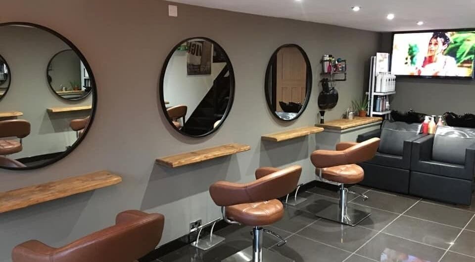Modern salon interior at Calum Maguire Hairdressing in Ayr, Scotland, GB, featuring stylish chairs and mirrors.