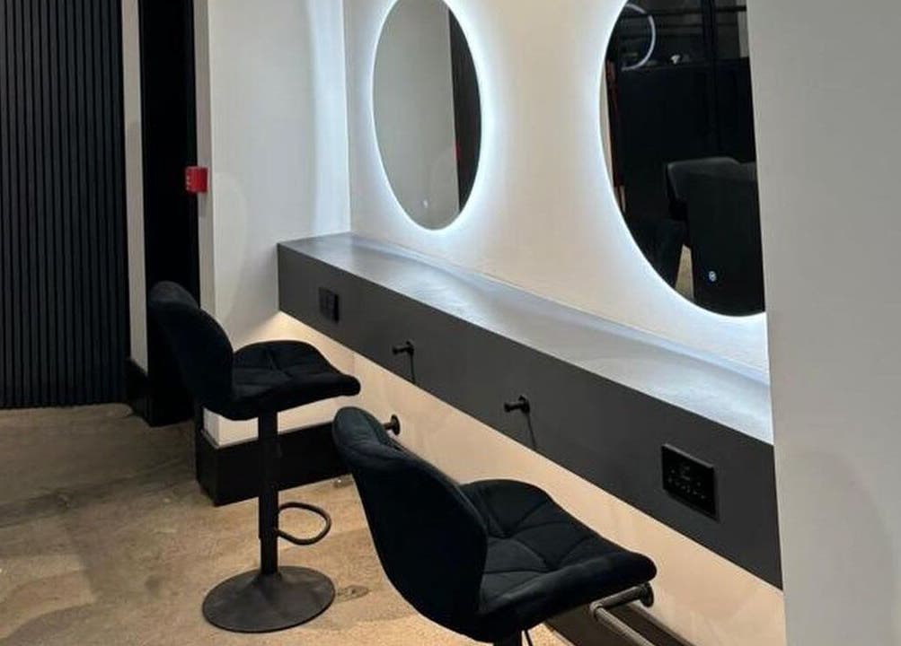Modern styling stations at Calum Maguire Hairdressing, Ayr, Scotland, GB, featuring sleek mirrors and seating.