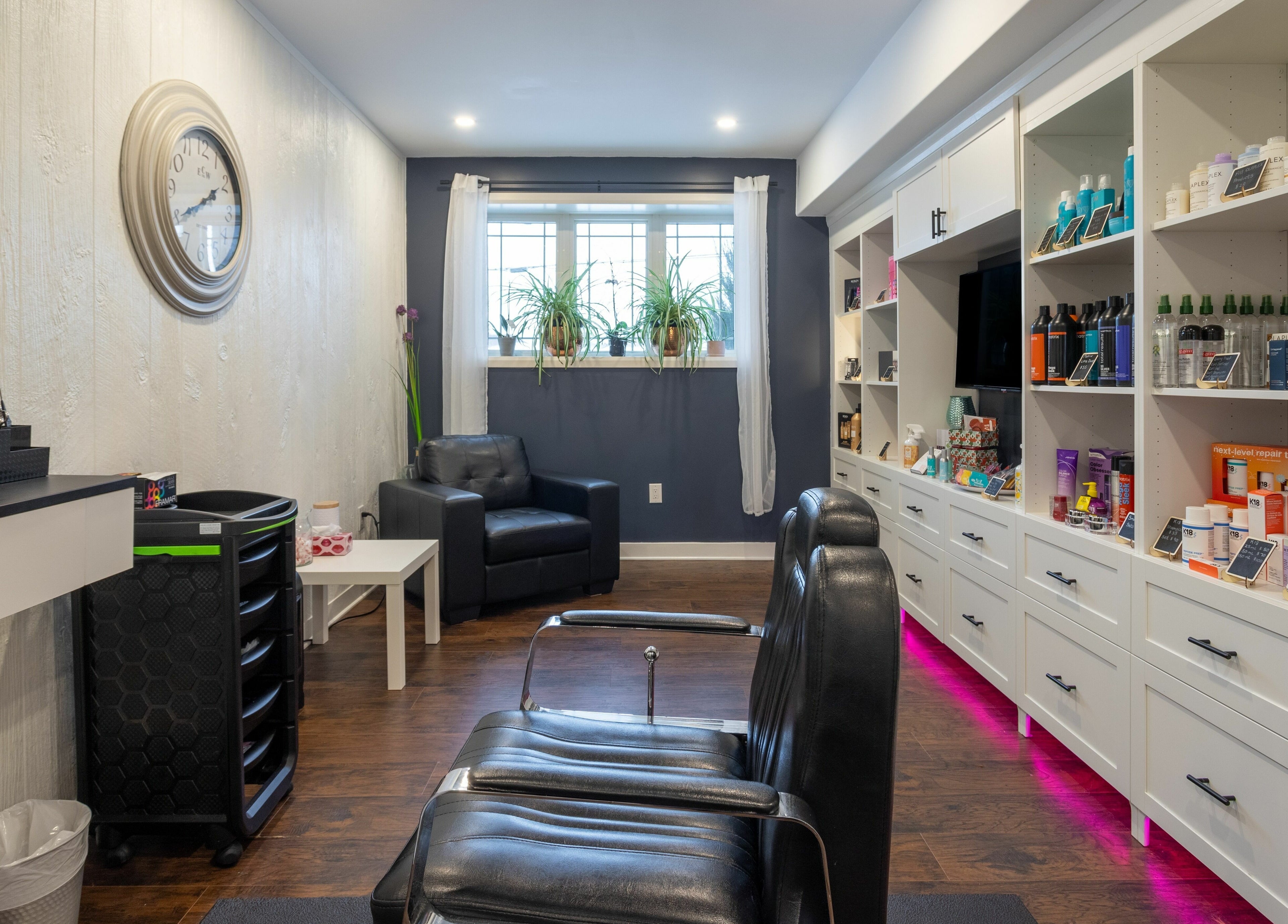 Modern interior of Erin's Hair Design in Bradford West Gwillimbury, Ontario, CA, featuring sleek styling chairs and product shelves.