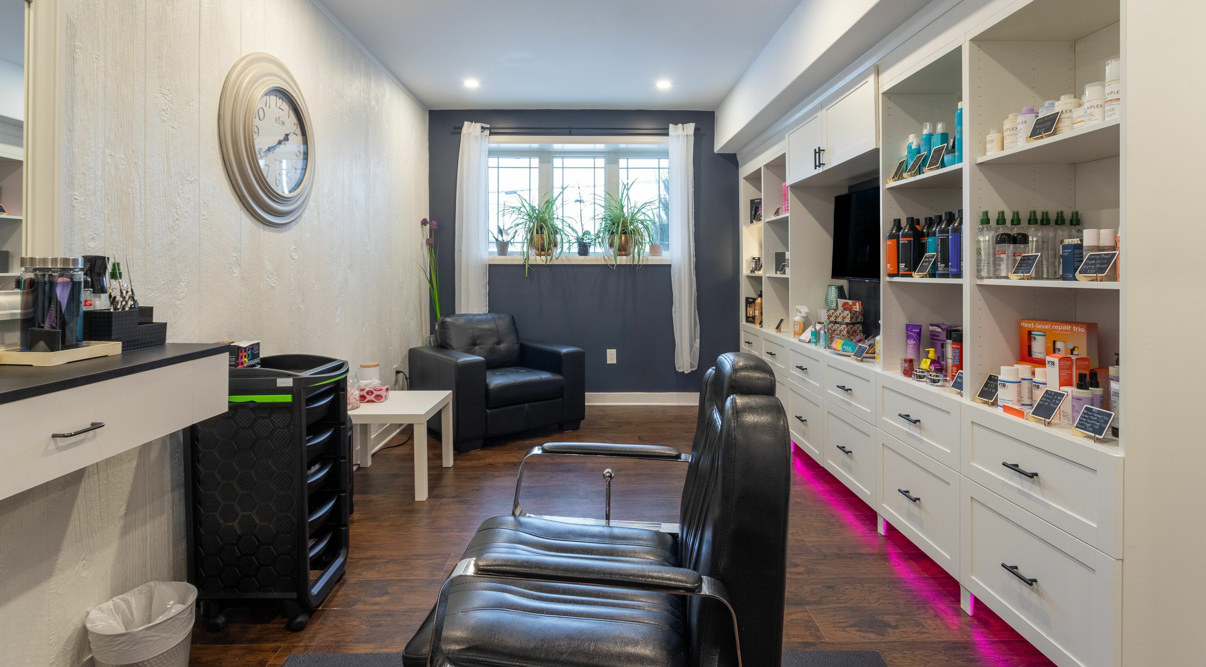 Modern interior of Erin's Hair Design in Bradford West Gwillimbury, Ontario, CA, featuring sleek styling chairs and product shelves.