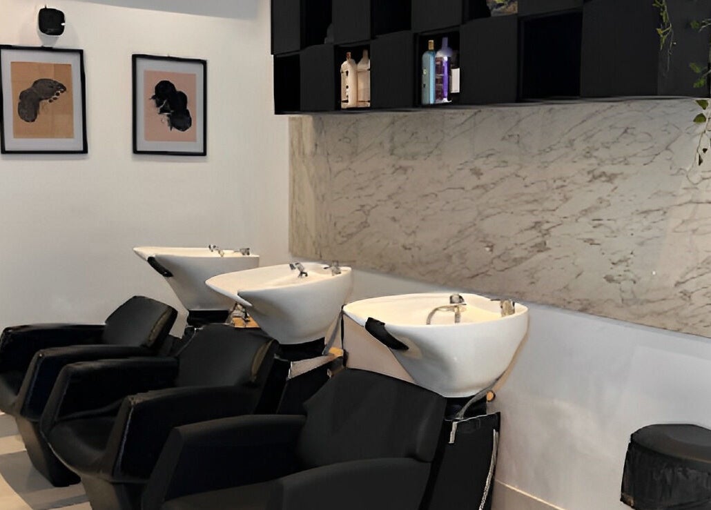 Modern wash stations at The Braiding Vault, Lekki, Lagos, NG elegantly designed with black chairs and marble accents.