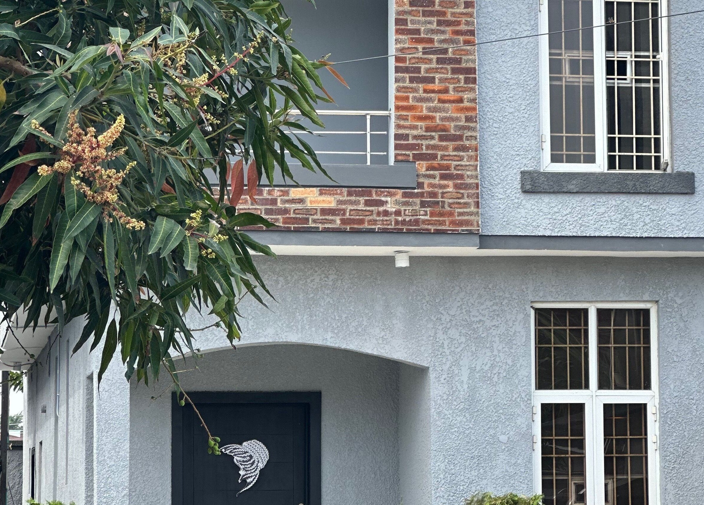 Exterior view of The Braiding Vault, Lekki, Lagos, NG, adorned with lush greenery.