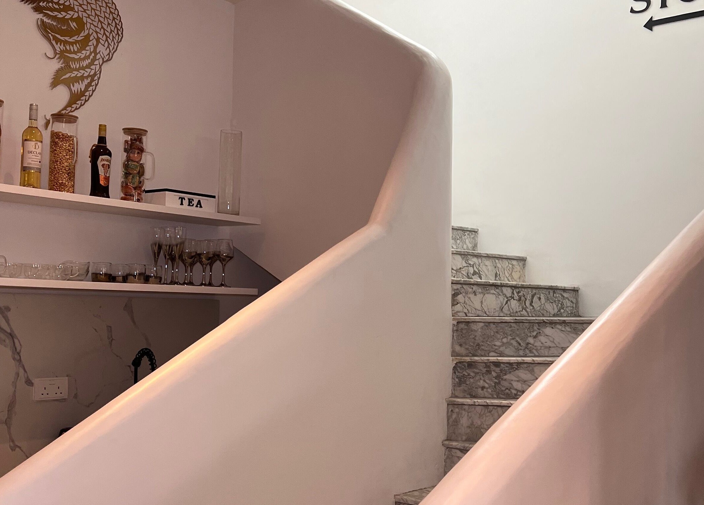Elegant marble stairway at The Braiding Vault, Lekki, Lagos, NG, featuring decorative shelves.