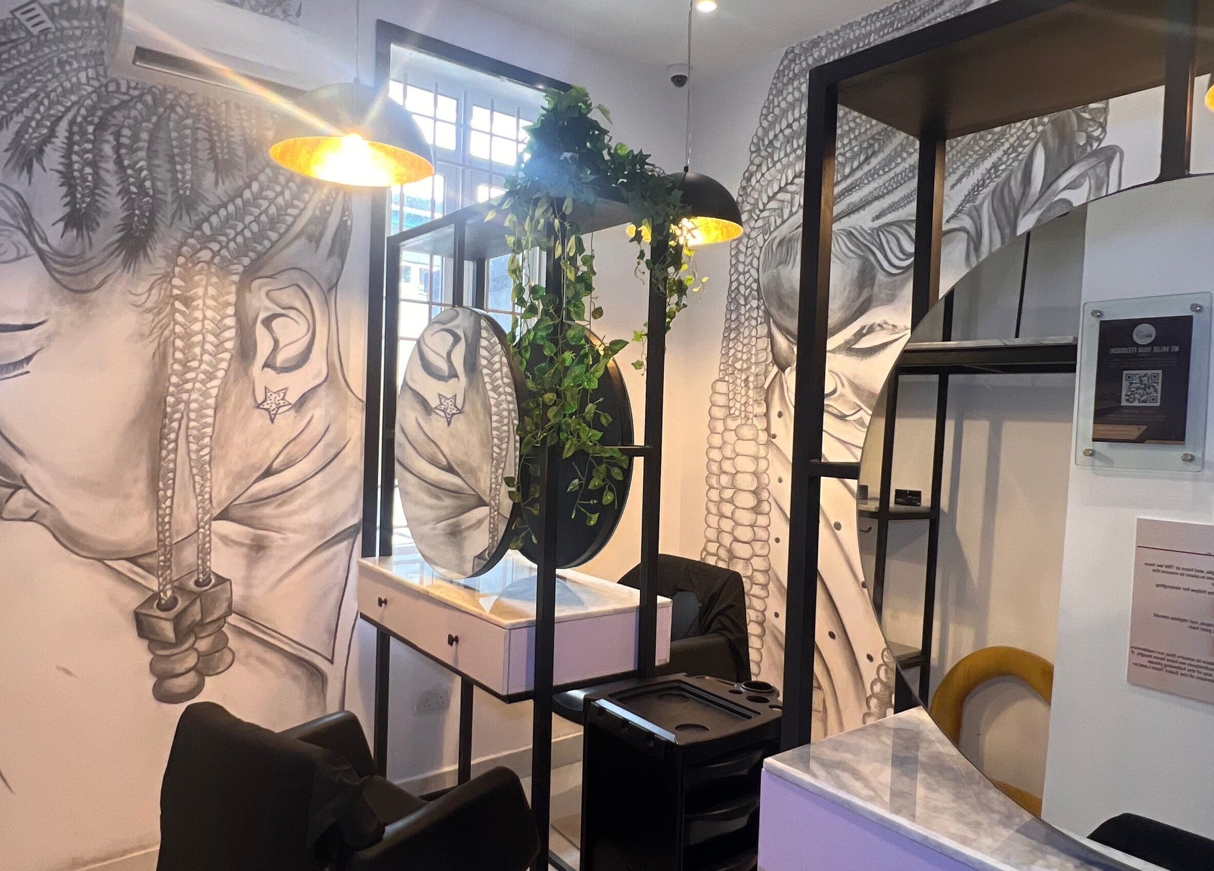 The Braiding Vault in Lekki, Lagos, NG: Cozy salon space with stunning braid-themed wall art, modern chairs, and mirrors.