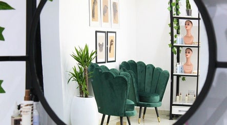 Elegant seating area in The Braiding Vault Signature, Lagos, Lagos, NG with green chairs and wall art.