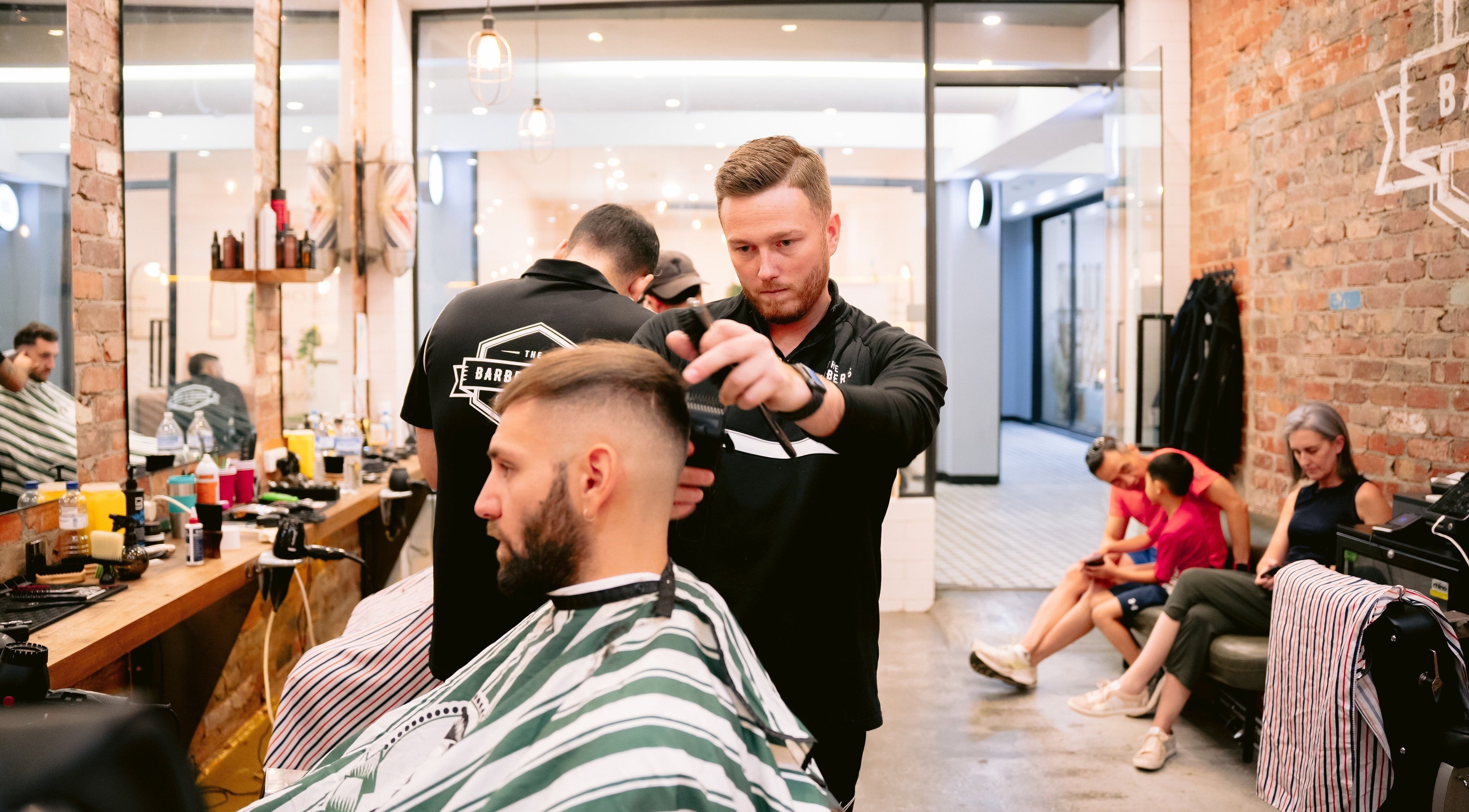 Barber at work in The Barbers Son Glenferrie, Melbourne, Victoria, AU, modern styling area.