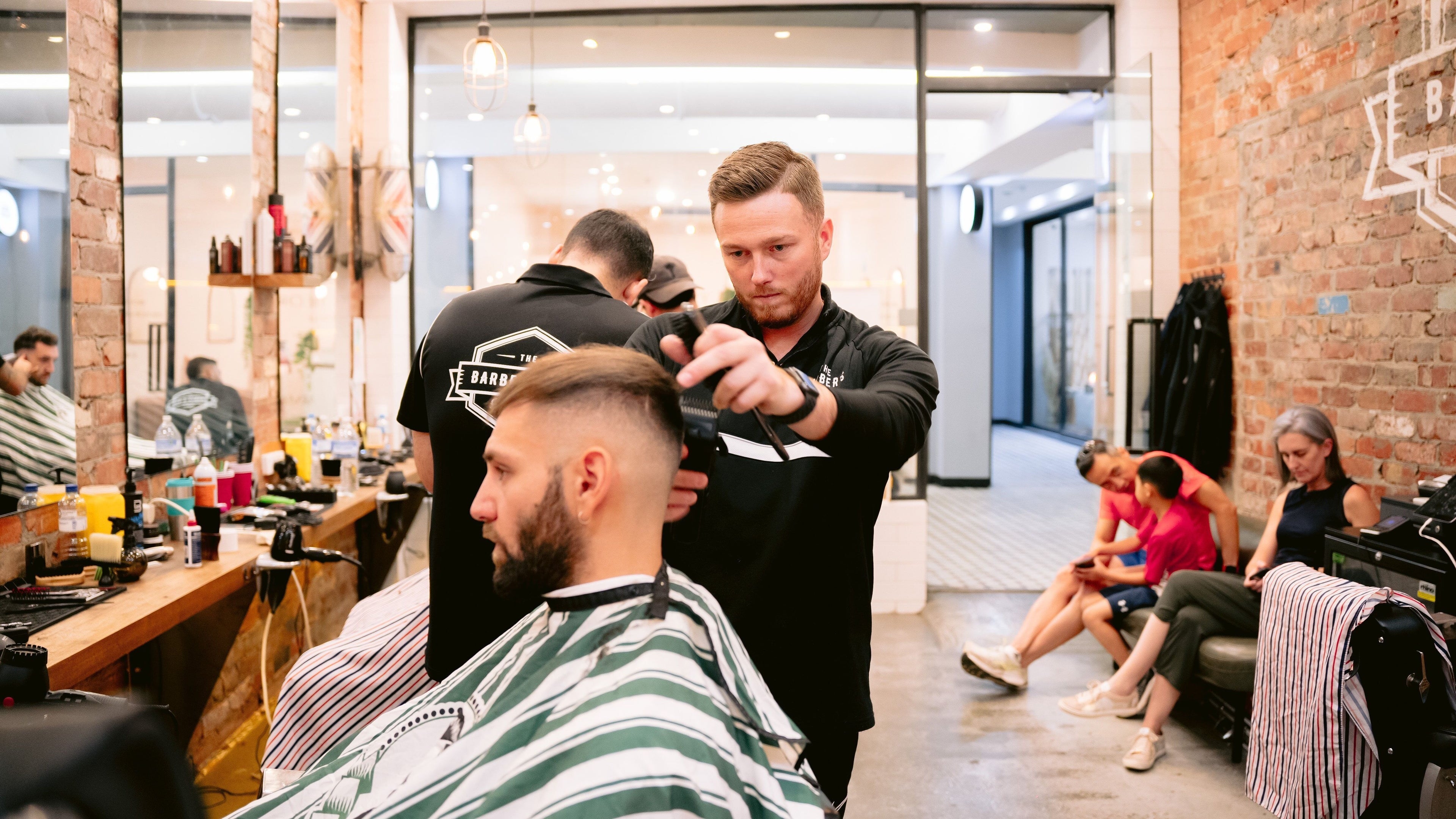 Barber at work in The Barbers Son Glenferrie, Melbourne, Victoria, AU, modern styling area.