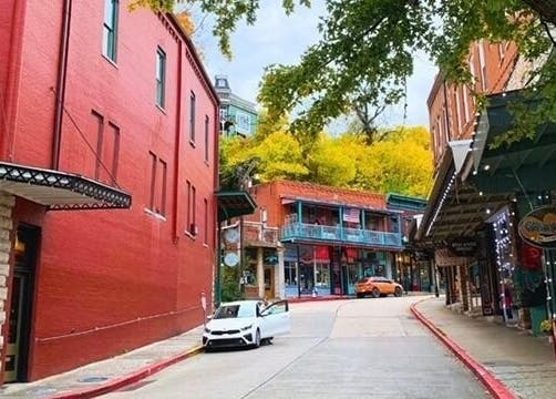 Picturesque street near Oracle & Sage - 78 Spring Street, Eureka Springs, Arkansas, US, showcasing vibrant buildings.