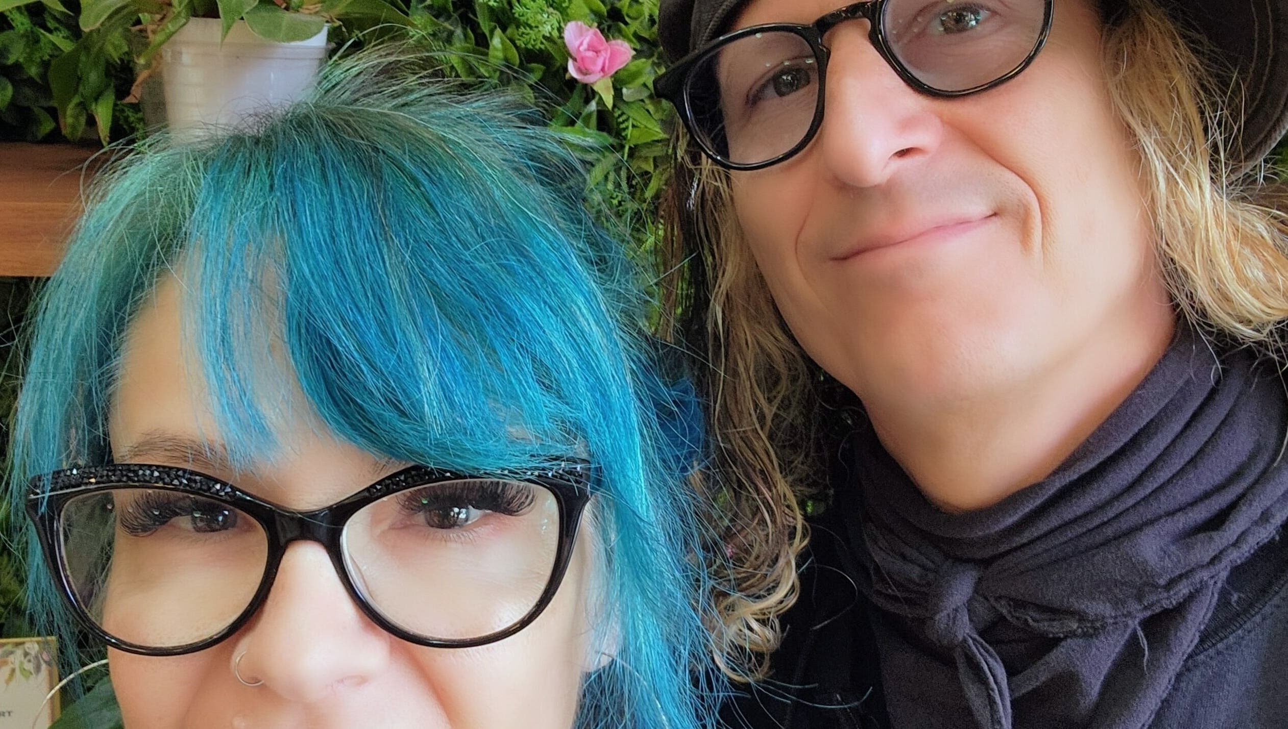 Two people smiling at Rockin Rollers, Sierra Madre, California, US with vibrant hairstyles and glasses.