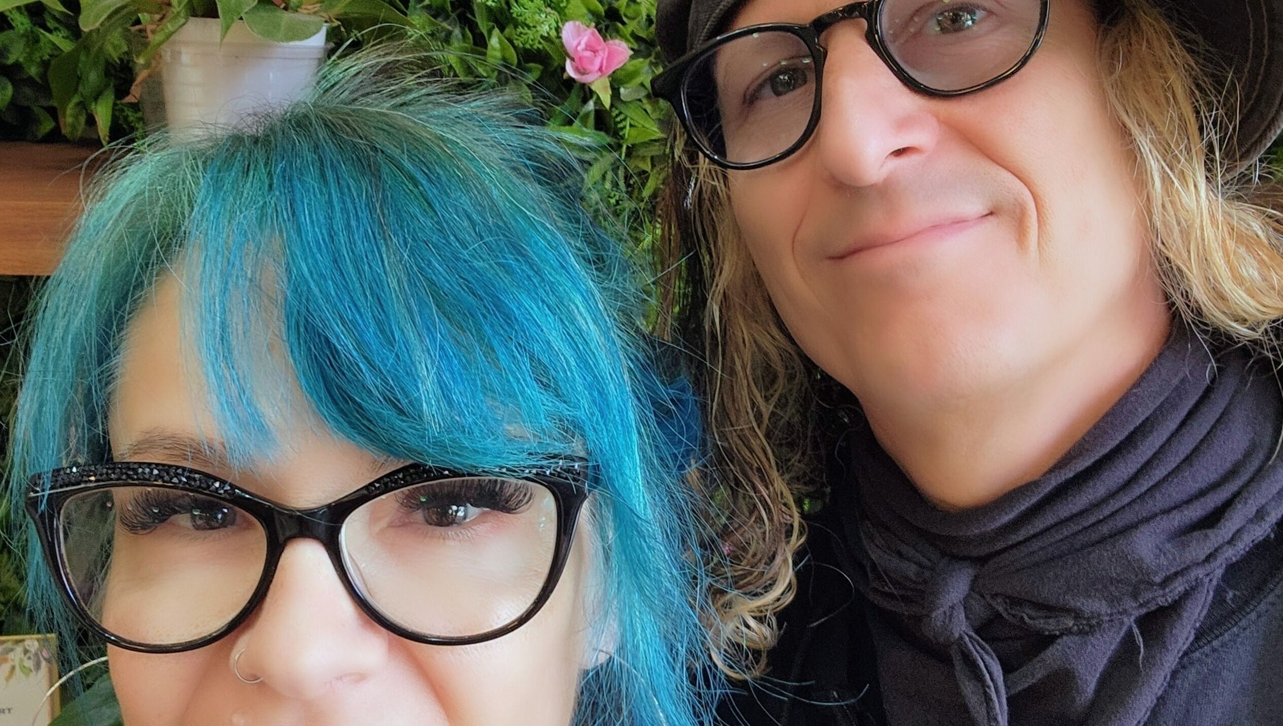 Two people smiling at Rockin Rollers, Sierra Madre, California, US with vibrant hairstyles and glasses.