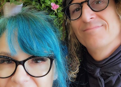Two people smiling at Rockin Rollers, Sierra Madre, California, US with vibrant hairstyles and glasses.