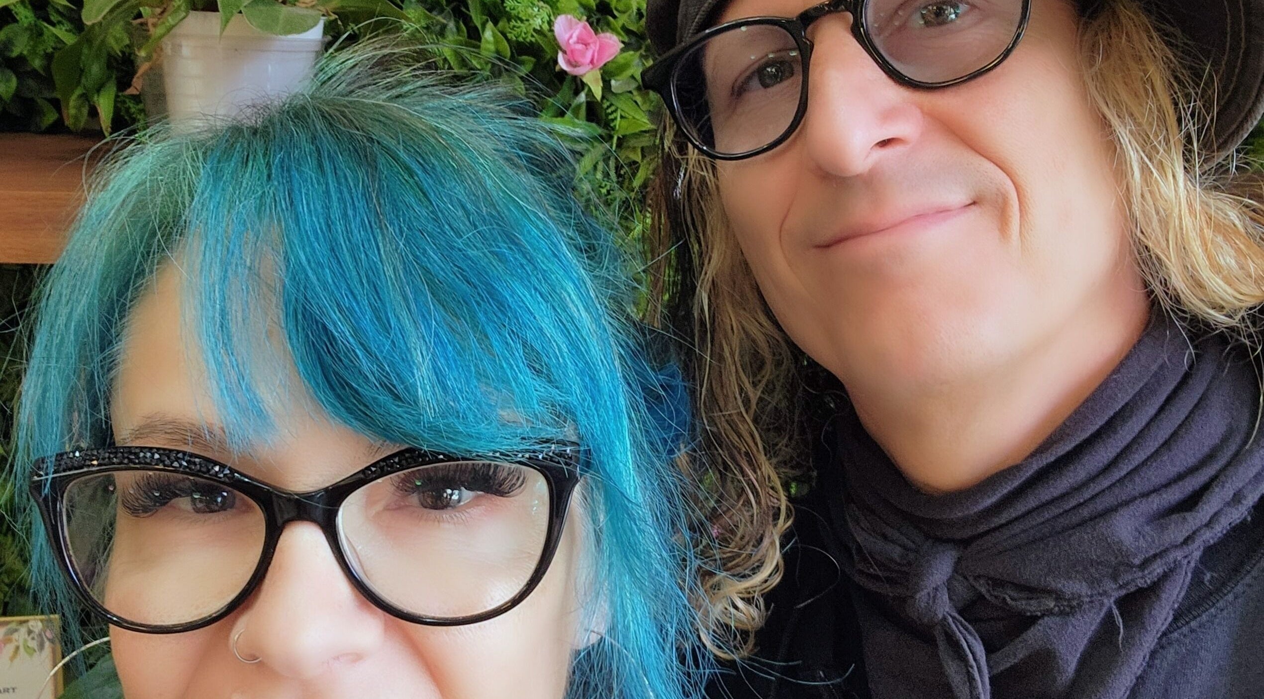 Two people smiling at Rockin Rollers, Sierra Madre, California, US with vibrant hairstyles and glasses.