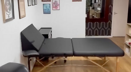 Cozy massage room at Bodiology Sussex in Eastbourne, England, GB with a massage table and calming decor.