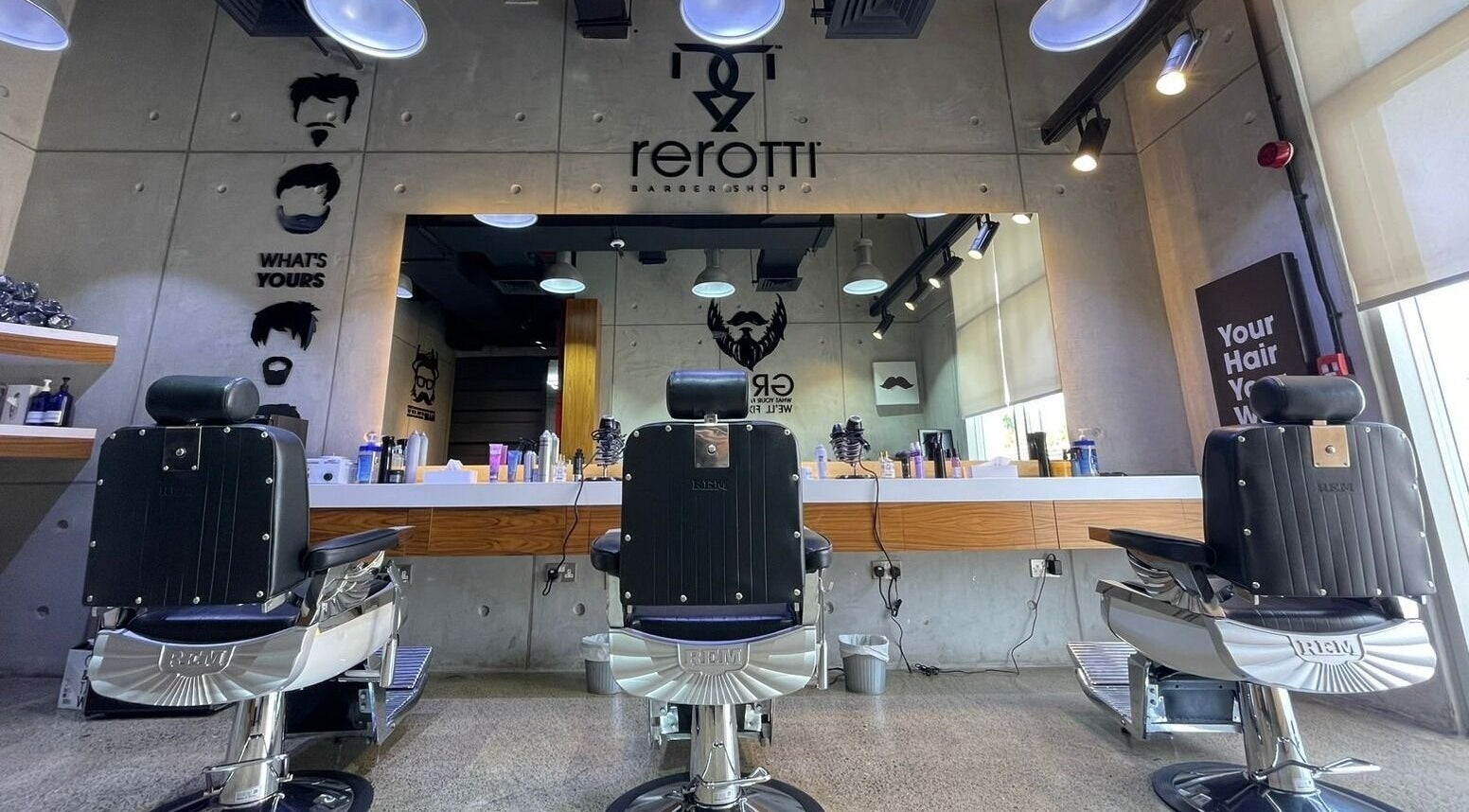 Sleek barber chairs at Rerotti Gents - Al Ghadeer in Abu Dhabi, AE, showcasing a contemporary interior.