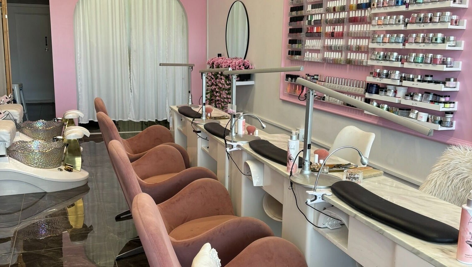 Elegant nail spa at Fearless Beauty, Auckland, Auckland, NZ with plush chairs and vibrant polish display.