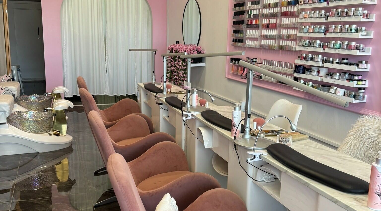 Elegant nail spa at Fearless Beauty, Auckland, Auckland, NZ with plush chairs and vibrant polish display.