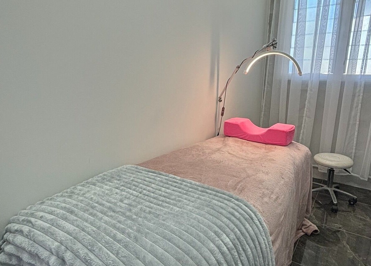 Cozy treatment room at Fearless Beauty, Auckland, NZ with soft lighting and massage table.