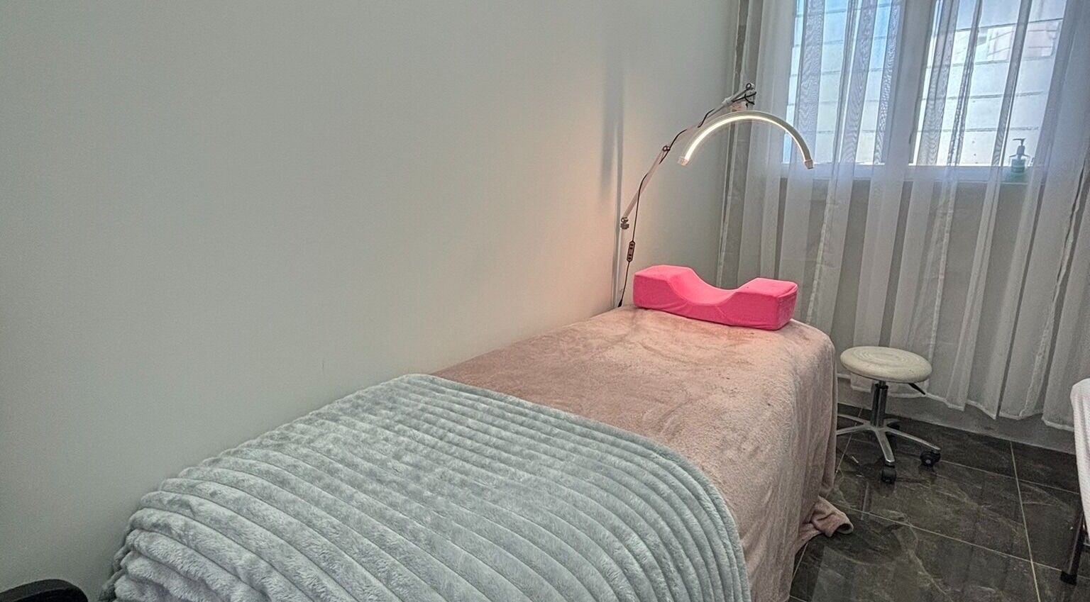 Cozy treatment room at Fearless Beauty, Auckland, NZ with soft lighting and massage table.