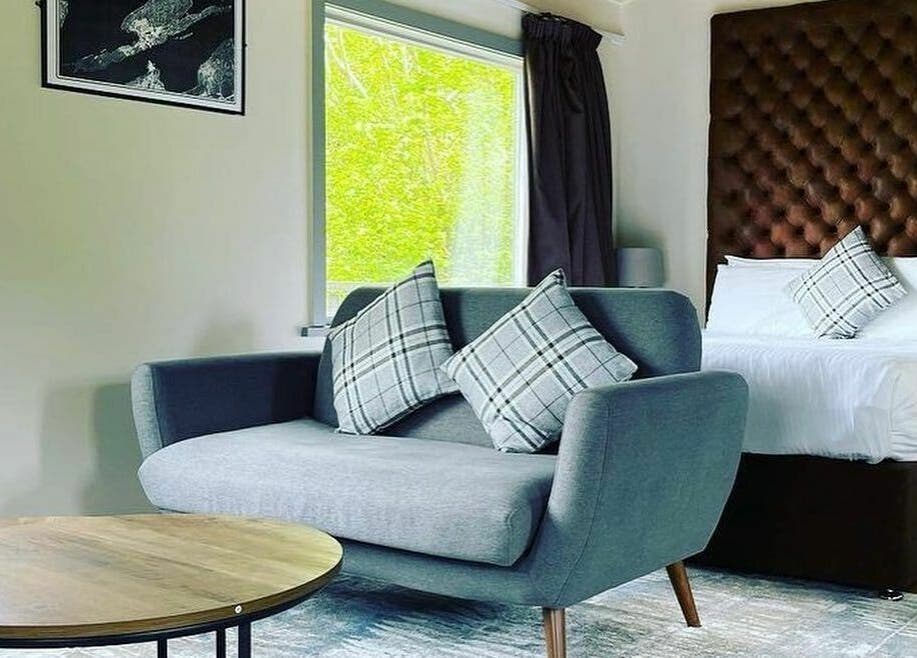 Luxurious room at Lusty Beg Island, Enniskillen, Northern Ireland, GB with stylish sofa and plush bedding.