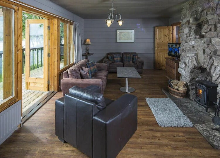 Cozy living room with stone fireplace at Lusty Beg Island, Enniskillen, Northern Ireland, GB.