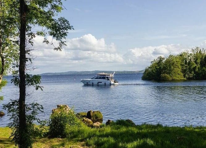 Scenic boat view at Lusty Beg Island, Enniskillen, Northern Ireland, GB, surrounded by trees and lake.