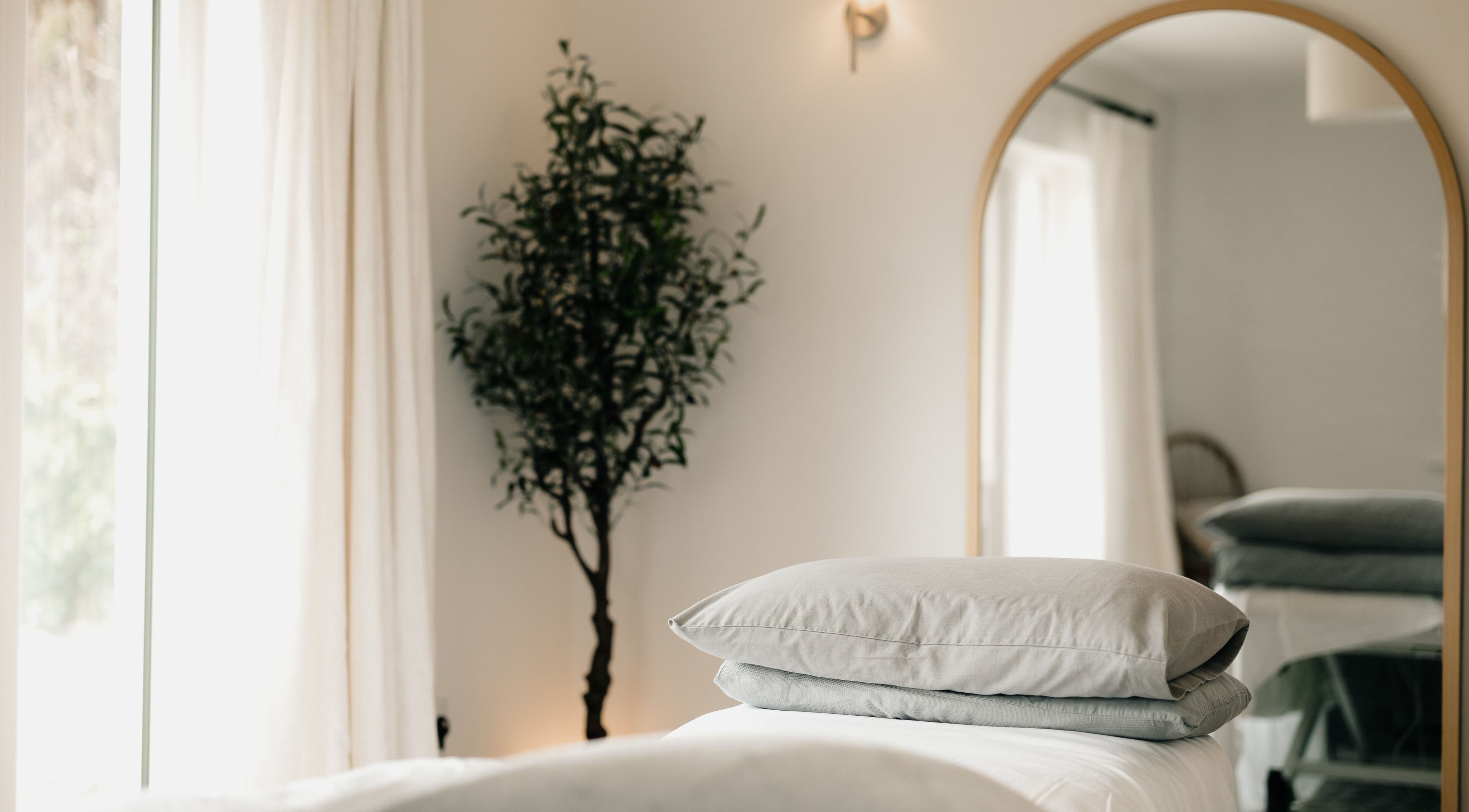 Relaxing massage room at Sãno Wellness | Amy O Mara, Lisnagry, IE with soft light and plush bedding.