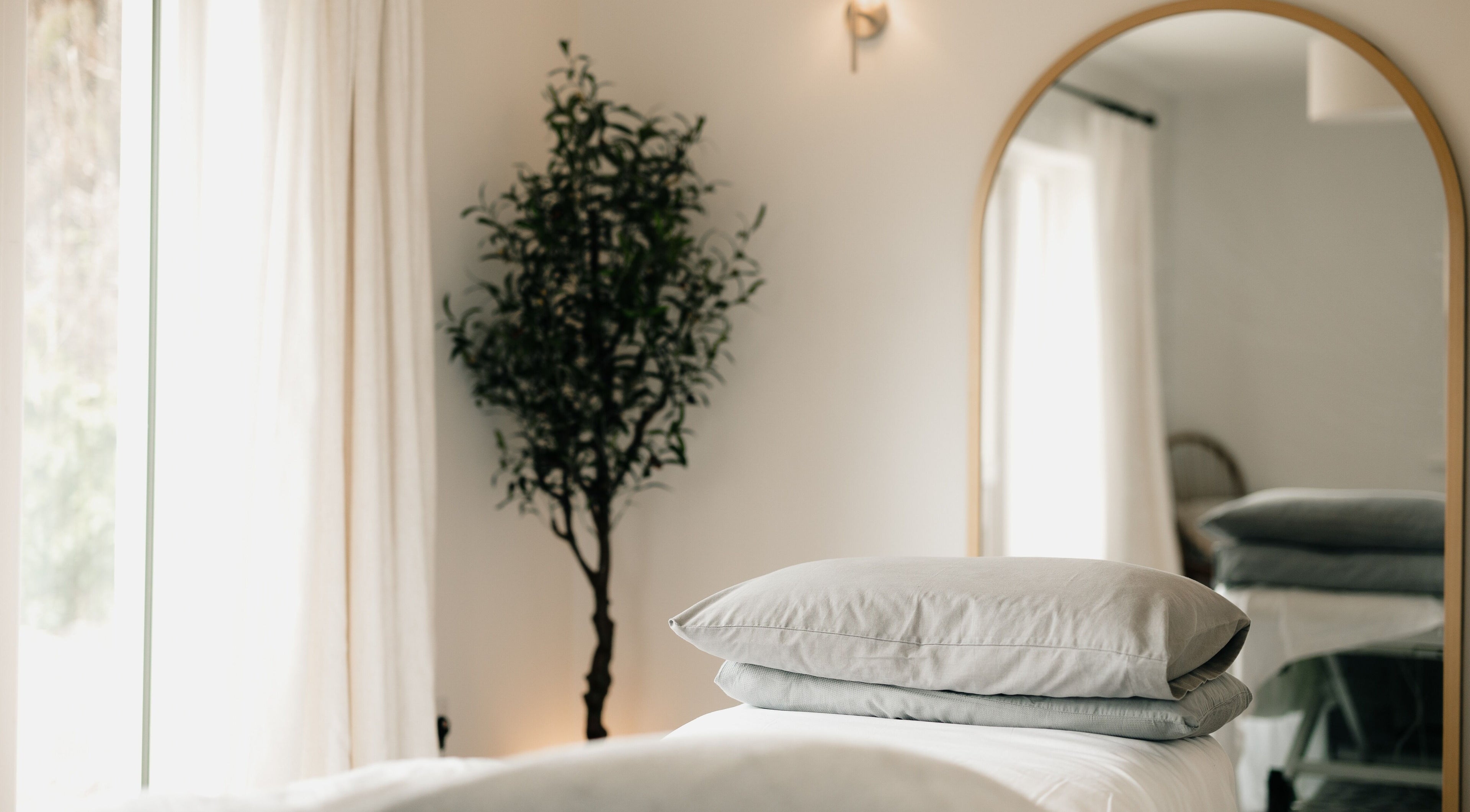 Relaxing massage room at Sãno Wellness | Amy O Mara, Lisnagry, IE with soft light and plush bedding.