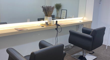 Modern hair styling workstation at Fragrance Hair Saloon, Cheras, Selangor, MY, featuring sleek chairs and mirrors.