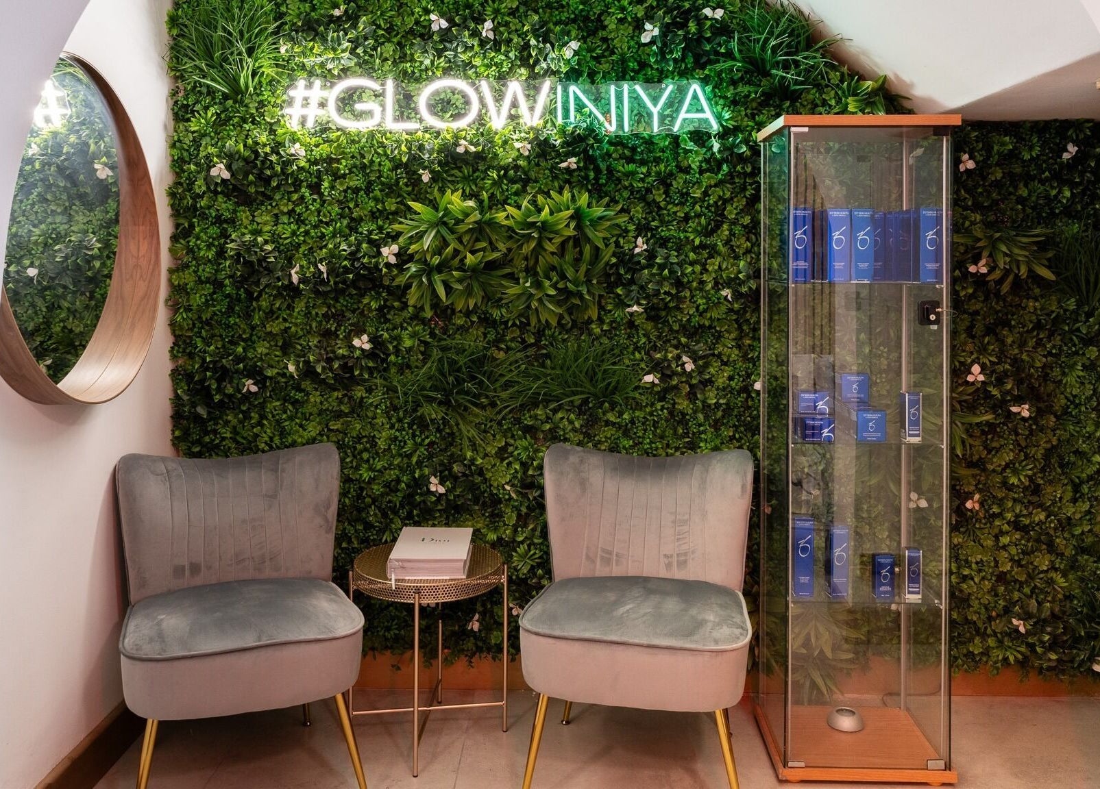 Lush green wall and chairs at INIYA Aesthetics & Laser Clinic, Stanmore, England, GB. #GLOWINIYA sign above.