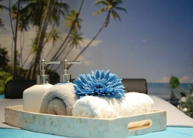 Relaxing spa setting at Silver Sea Day Spa, San Jose, California, US with towels and a soothing blue flower.