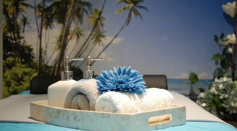 Relaxing spa setting at Silver Sea Day Spa, San Jose, California, US with towels and a soothing blue flower.