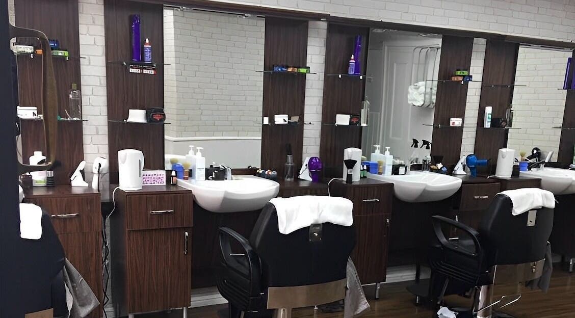 Modern barber stations at First Class Barber in Ware, England, GB showcasing stylish chairs and grooming tools.