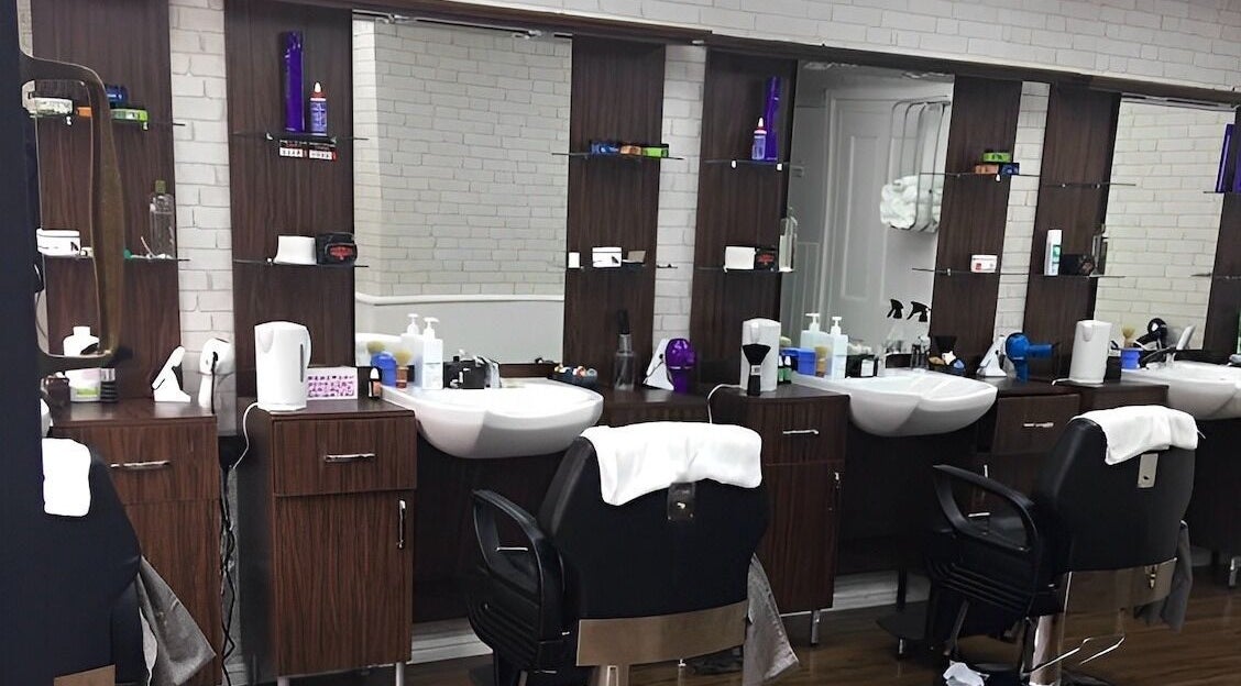 Modern barber stations at First Class Barber in Ware, England, GB showcasing stylish chairs and grooming tools.