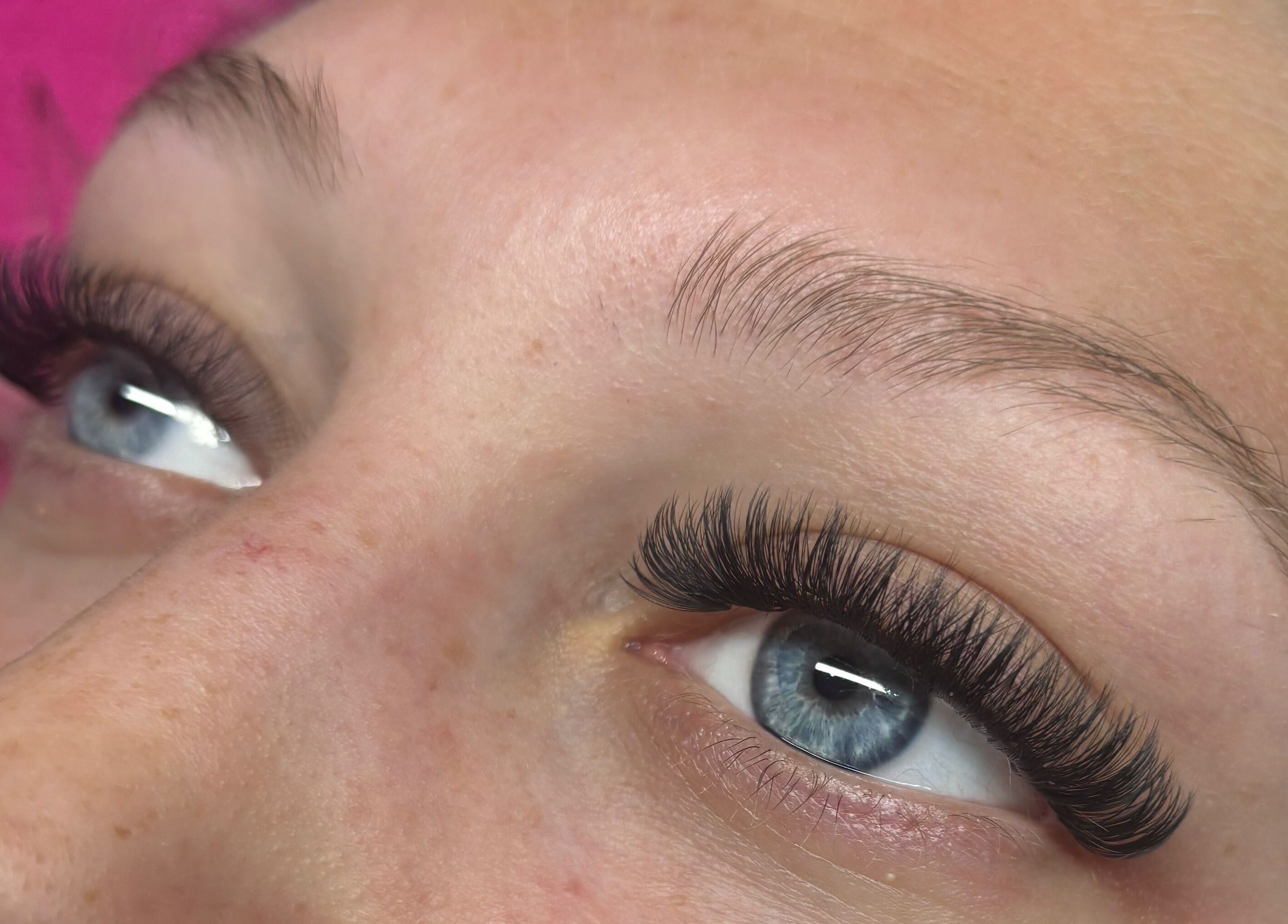 Close-up of elegant eyelash extensions from Wild Honey Lash Co in Calgary, Alberta, CA, highlighting blue eyes.