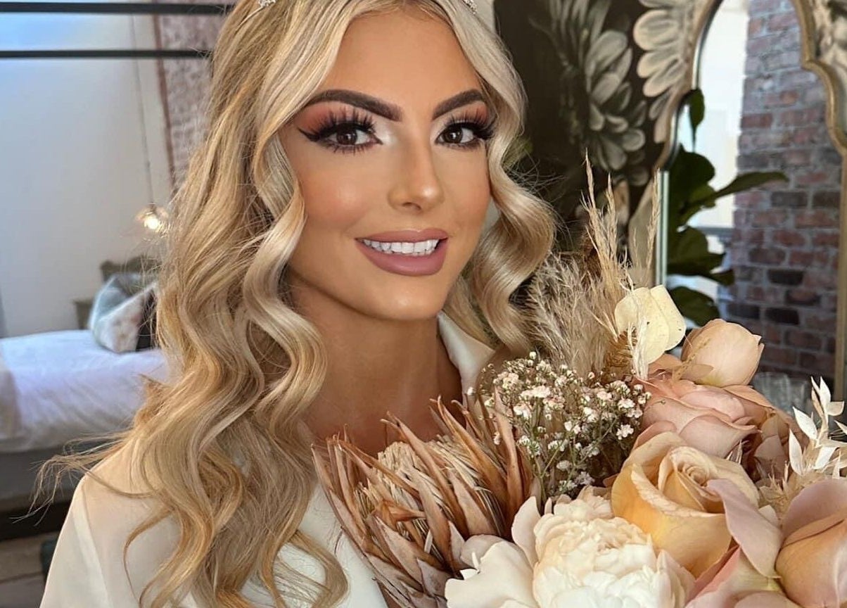 Radiant woman holding bouquet at Belle Ame Beauty and Nails, Millwater, Auckland, NZ.