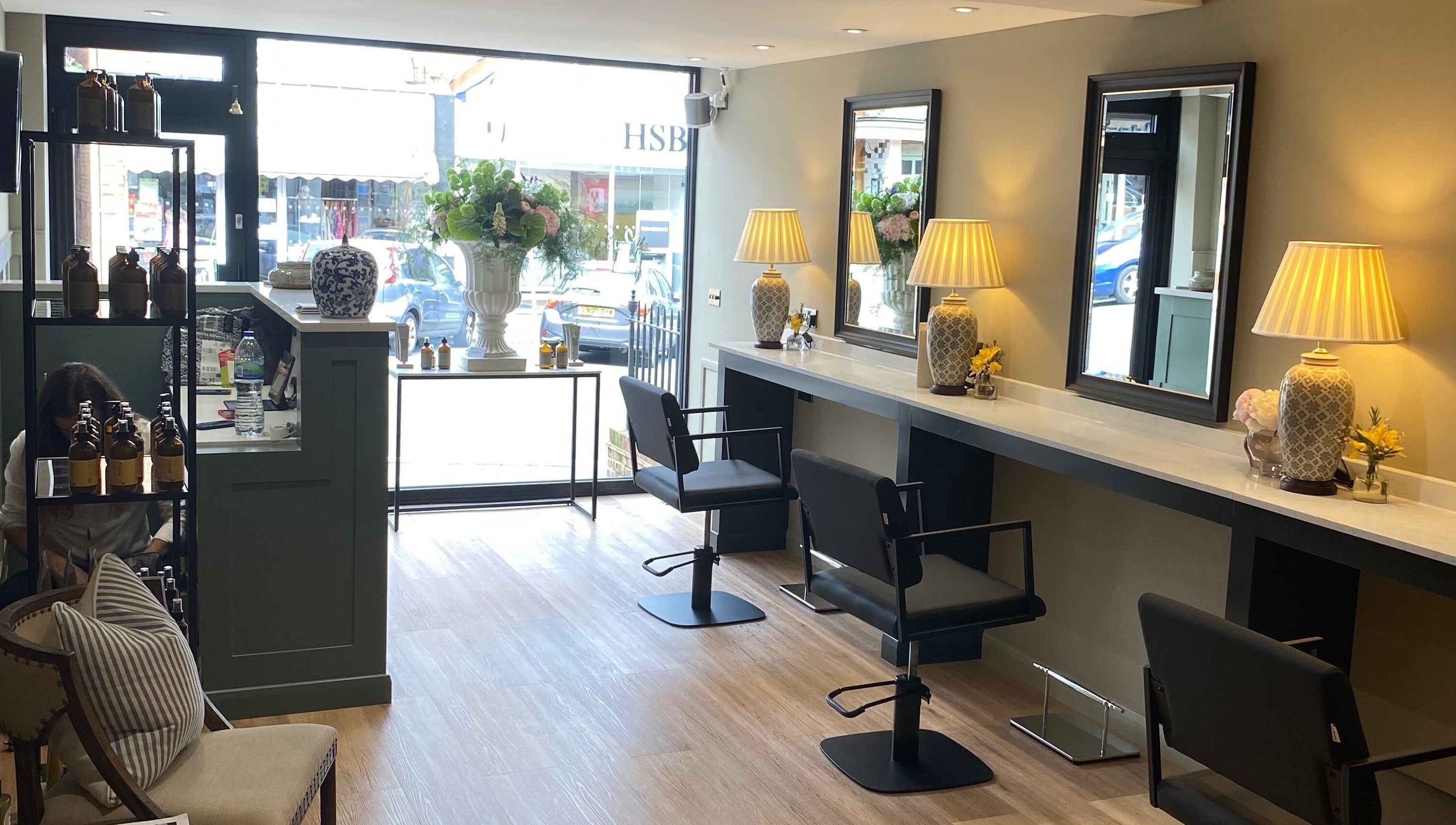 Interior of Adam James Oxted on Oxted High Street, England, featuring elegant salon chairs and decor.