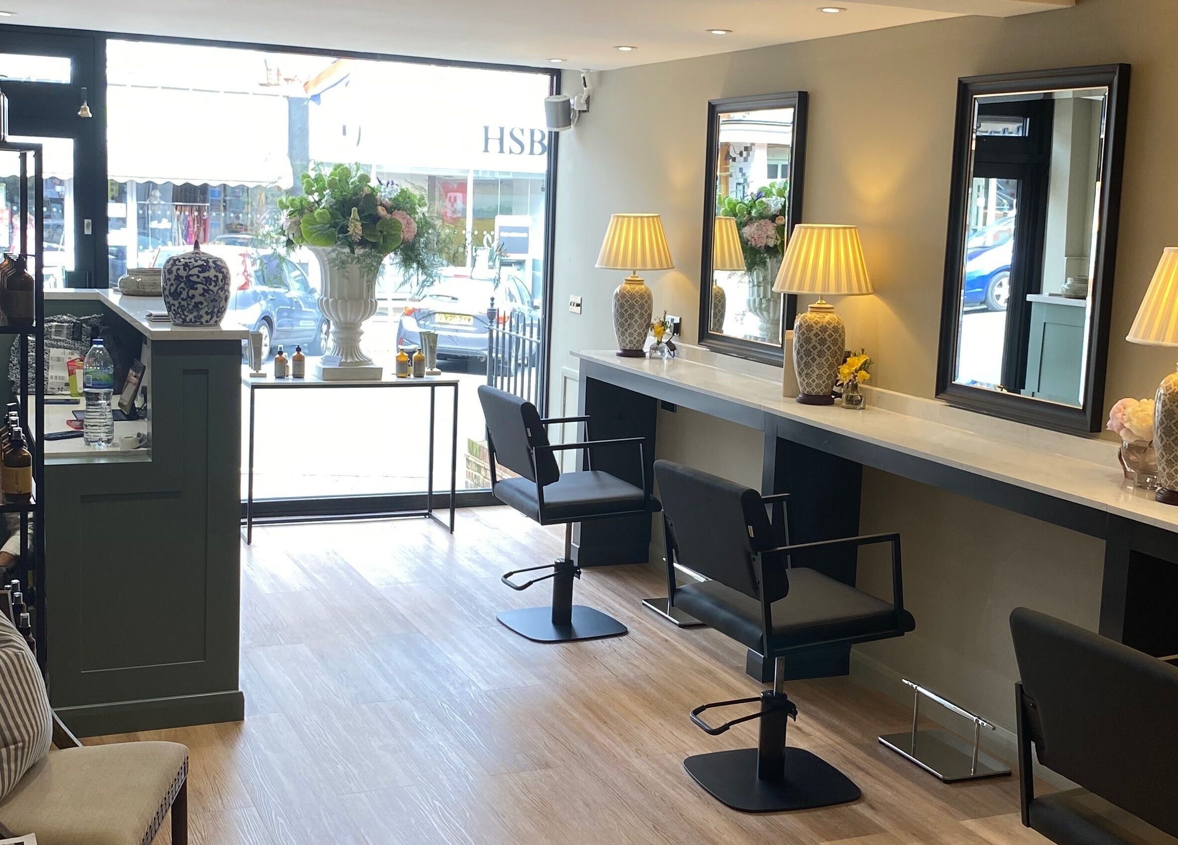 Interior of Adam James Oxted on Oxted High Street, England, featuring elegant salon chairs and decor.