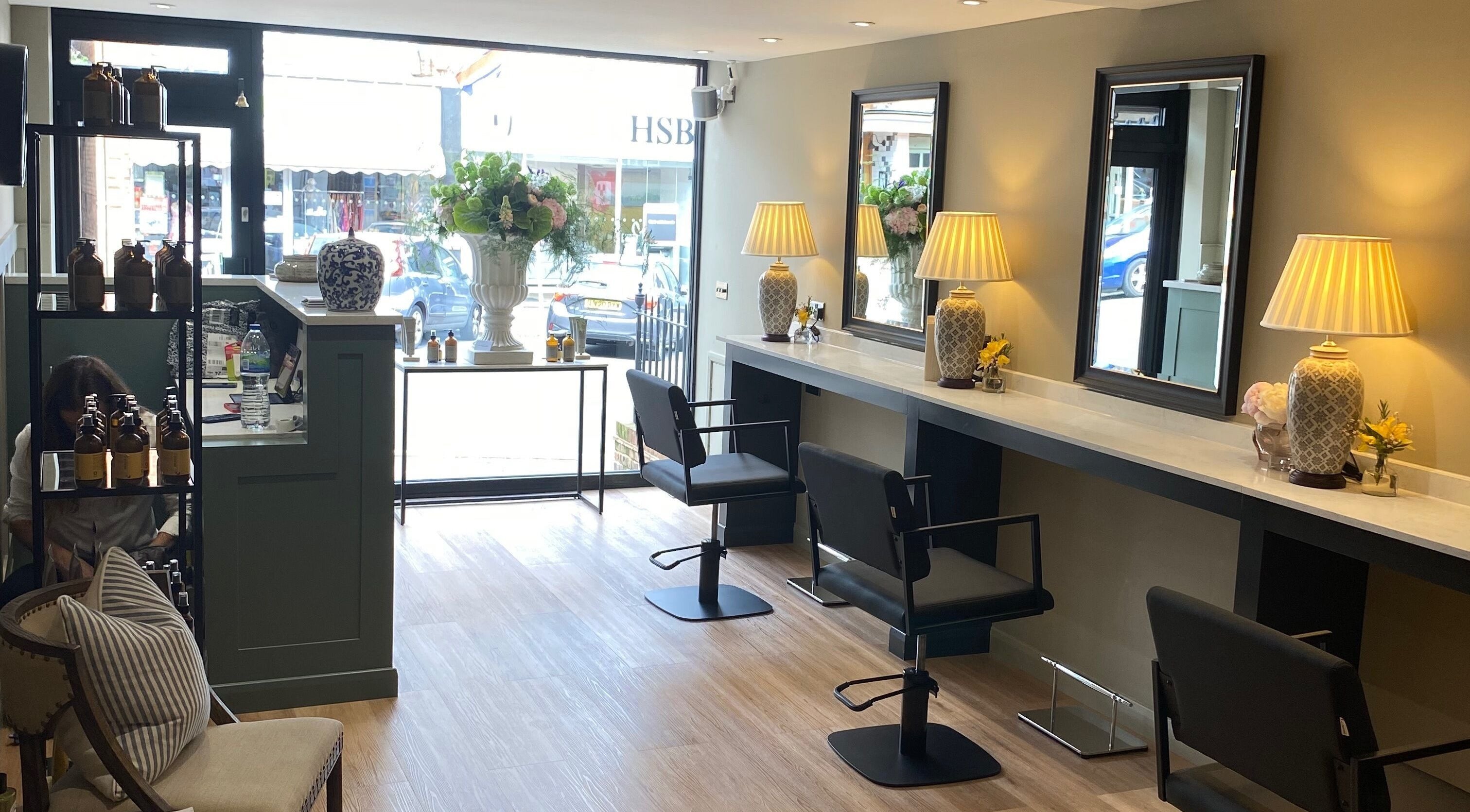 Interior of Adam James Oxted on Oxted High Street, England, featuring elegant salon chairs and decor.