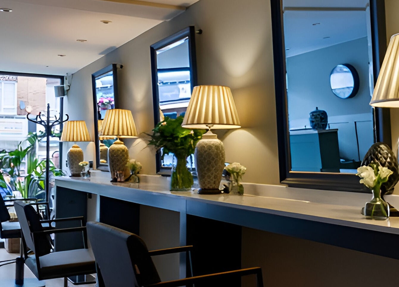 Elegant salon interior at Adam James Oxted, Oxted High Street, England, GB with chic mirrors and ambient lighting.