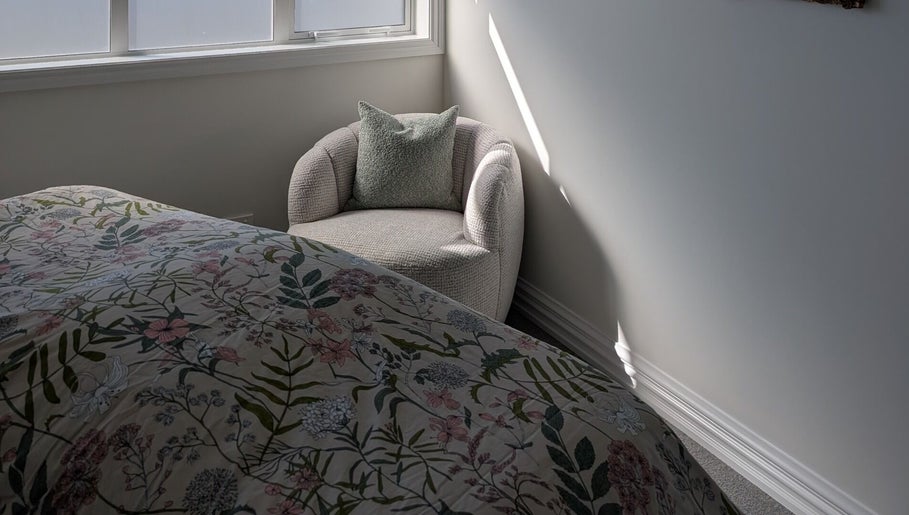 Serene bedroom at My Beauty Treat, Rangiora, Canterbury Region, NZ, featuring a floral bedspread and armchair.